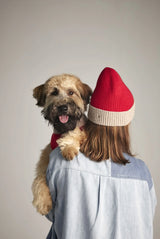 Woman wearing our Wool and Cashmere Red and white Beanie and a dog in her arms close-up